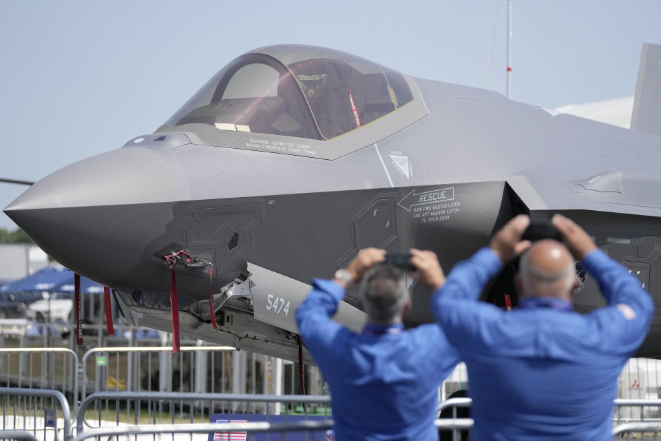 FILE - Visitors take pictures of a F35 Lightning 2 fighter plane at the Farnborough Air Show fair in Farnborough, England, Monday, July 18, 2022. The future for fighter pilots was on display at the Farnborough International Airshow near London, one of the world’s biggest aviation, defense and aerospace expos. New technologies take on a bigger role in the cockpit, redefining what it means to be a ''Top Gun''. (AP Photo/Frank Augstein, File)