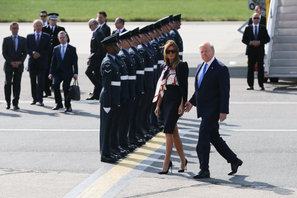 Melania Trump and Donald Trump walk across the tarmac at Stansted Airport on their way to meet the Queen