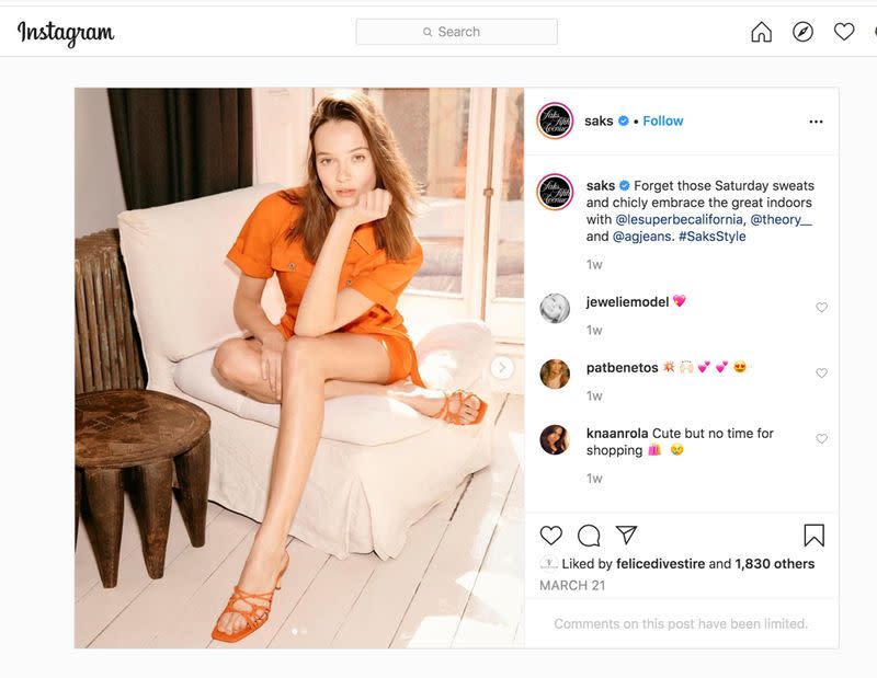 A model poses in an orange $395 outfit sold by department store operator Saks Fifth Avenue