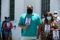 <p>Mourners looked on as Lewis arrived in Montgomery, Alabama. Individuals wore masks in order to protect themselves and other from COVID-19. They also carried signs with Lewis's iconic police mugshot depicted on the front. In 2014, Lewis <a href="https://www.nbcnews.com/news/us-news/rep-john-lewis-tweets-his-mugshot-educate-inform-n150261" rel="nofollow noopener" target="_blank" data-ylk="slk:tweeted;elm:context_link;itc:0;sec:content-canvas" class="link ">tweeted</a> this photograph to educate his followers about the history of racism in the United States. The caption read, "53 yrs ago today I was released from Parchman Penitentiary after being arrested in Jackson for using the 'white' restroom."<br></p>