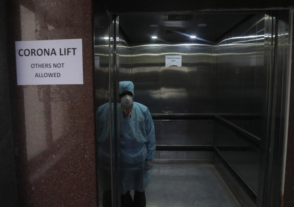 An Indian lift operator stands inside a dedicated lift for people suspected to have the coronavirus at the Government Gandhi Hospital in Hyderabad, India, Monday, March 2, 2020. (AP Photo/Mahesh Kumar A.)