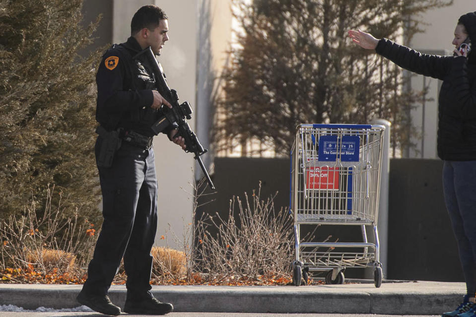 A law enforcement officer directs people outside the Fashion Place mall after a shooting in Murray, Utah, Sunday, Jan. 13, 2019. (Trent Nelson/The Salt Lake Tribune via AP)