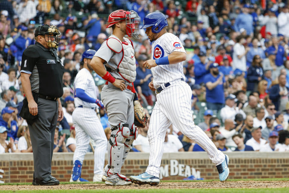 Chicago Cubs' Willson Contreras, right, scores on a single hit by Frank Schwindel against the St. Louis Cardinals during the sixth inning of the first baseball game of a doubleheader, Saturday, June 4, 2022, in Chicago. (AP Photo/Kamil Krzaczynski)