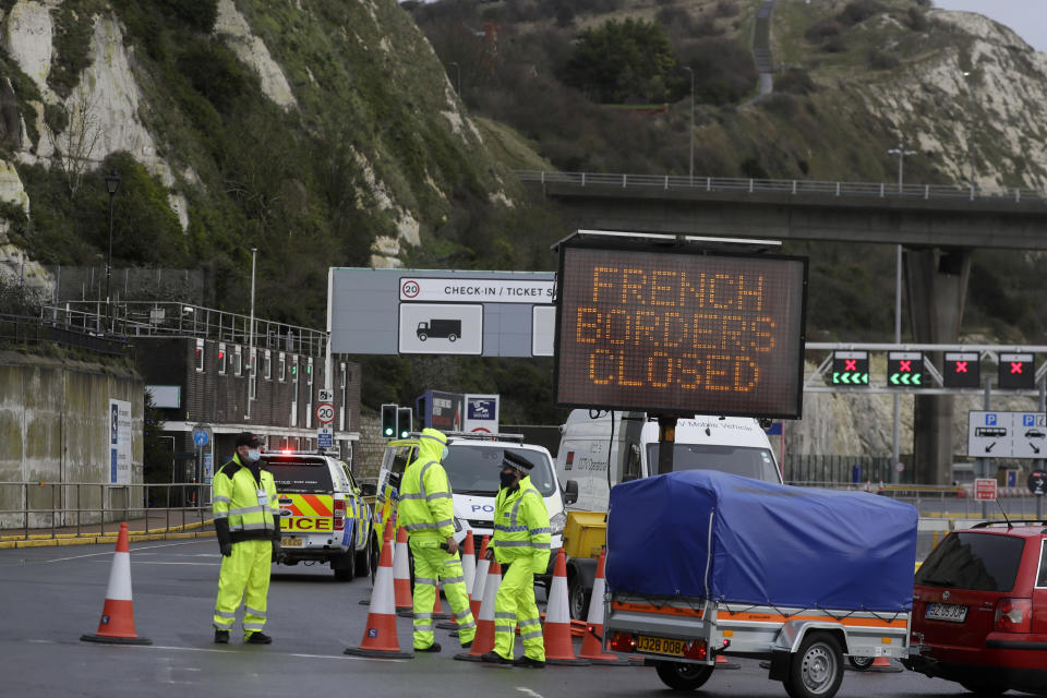 Security officers guard the entrance to the ferry check-in as the Port of Dover remains closed, in Dover, the main ferry link between southern England and France, Tuesday, Dec. 22, 2020. Trucks waiting to get out of Britain backed up for miles and people are left stranded at airports as dozens of countries around the world slapped tough travel restrictions on the U.K. because of a new and seemingly more contagious strain of the coronavirus in England.(AP Photo/Kirsty Wigglesworth)