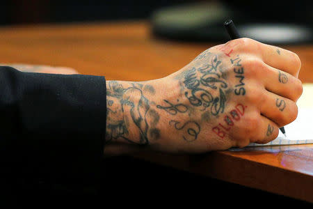 FILE PHOTO - Former New England Patriots tight end Aaron Hernandez writes a note during his murder trial at Bristol County Superior Court in Fall River, Massachusetts, U.S. on February 4, 2015. REUTERS/Brian Snyder/File Photo