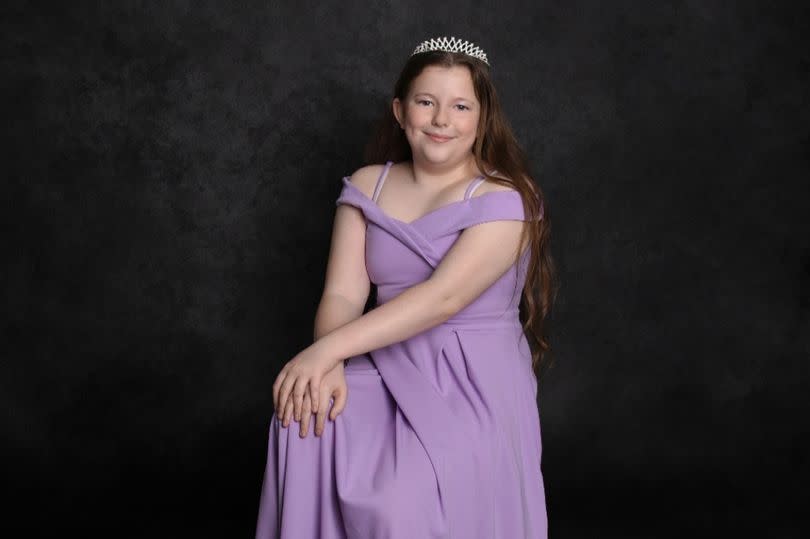 A young girl in a purple dress