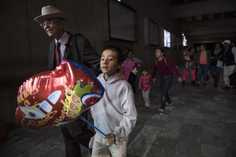 FILE - Anthony David Tovar Ortiz, center, is accompanied by attorney Ricardo de Anda after arriving at La Aurora airport in Guatemala City, Guatemala on Tuesday, Aug. 14, 2018. The 8-year-old stayed in a shelter for migrant children in Houston after his mother, Elsa Ortiz Enriquez, was deported in June 2018 under President Donald Trump's administration's zero tolerance policy. Stalled negotiations for the U.S. government to pay families separated at the border during Trump's presidency have brought new threats of extortion. Attorney De Anda asked the Biden administration to consider admitting family members who were threatened since the news reports. The administration has focused on parents and children who were separated but says it will consider additional families case-by-case. (AP Photo/Oliver de Ros, File)
