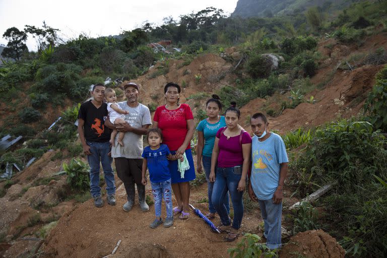 Melvin Alonso, 14; Guillermo Alonso, 54; Elvin Alonso, 6 meses; María Orellana, 52; Génesis Alonso, 6; Yenny Alonso, 16; Areli Alonso, 22, y Orlin Alonso, 25, posan para una foto en el sitio donde su casa fue destruida por un deslizamiento de tierra provocado por los huracanes Eta e Iota en la aldea de La Reina, Honduras 