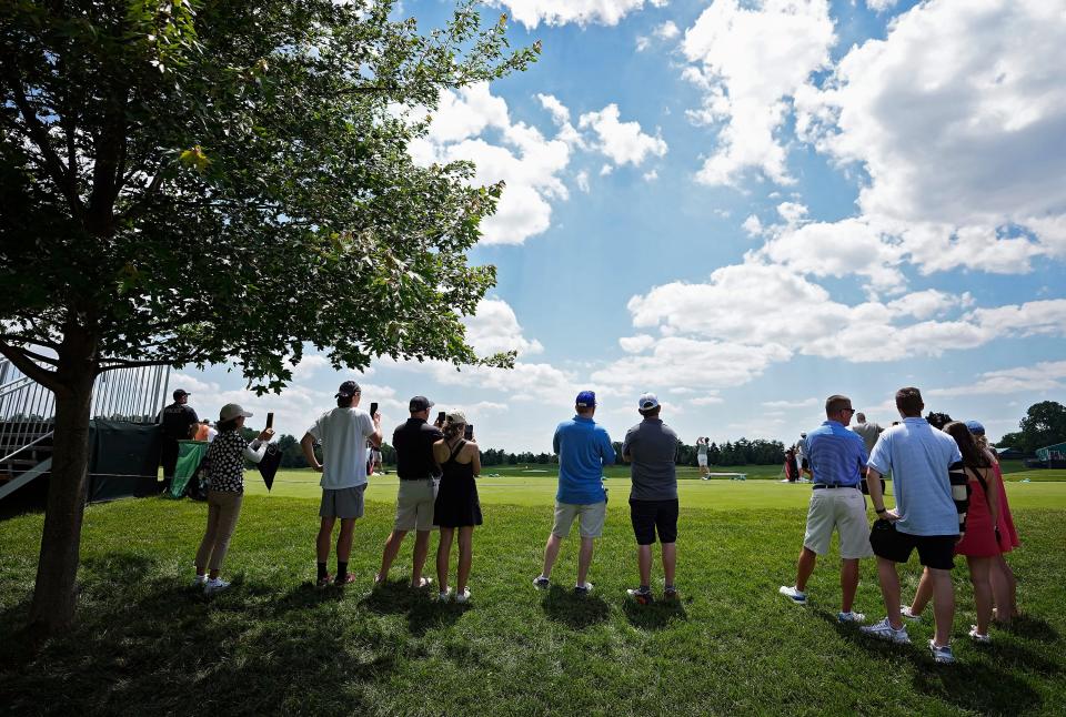 Patrons watch golfers practice Monday afternoon before the start of the Memorial Tournament at Muirfield Village Golf Club in Dublin, Ohio.