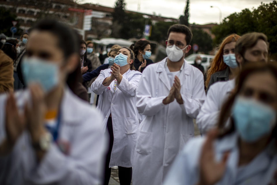 Healthcare workers protest against plans by Madrid's authorities to force staff to transfer to other hospitals at La Paz hospital in Madrid, Spain, Friday, Jan. 22, 2021. Virus infections have been increasing steeply following Christmas and New Year, putting pressure on Spain's public health system. (AP Photo/Manu Fernandez)