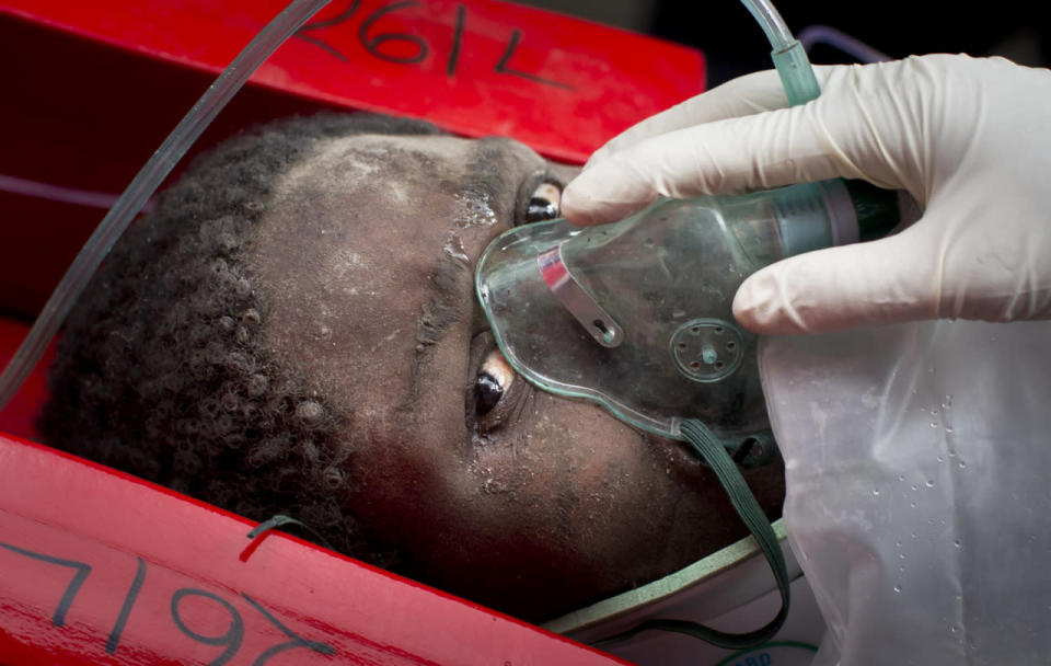 <p>Elizabeth Night Odhiambo is carried away in a stretcher by medics as she is rescued after being trapped for six days in the rubble of a collapsed building in the Huruma section of Nairobi, Kenya, May 5, 2016. <i>(Photo: Ben Curtis/AP)</i></p>