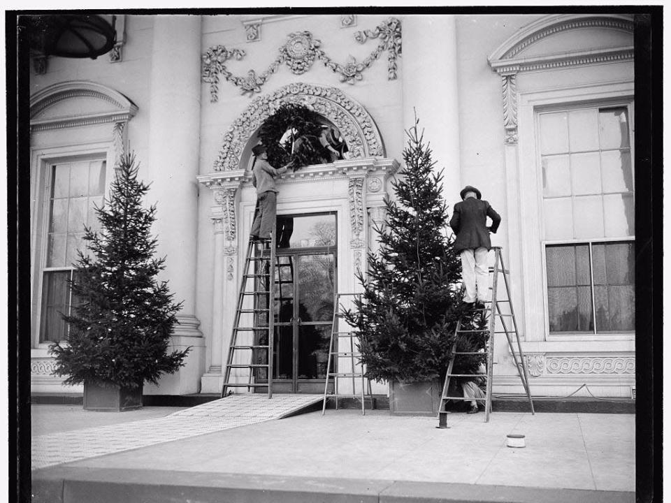 Installing a Christmas wreath at the White House entrance in 1937.