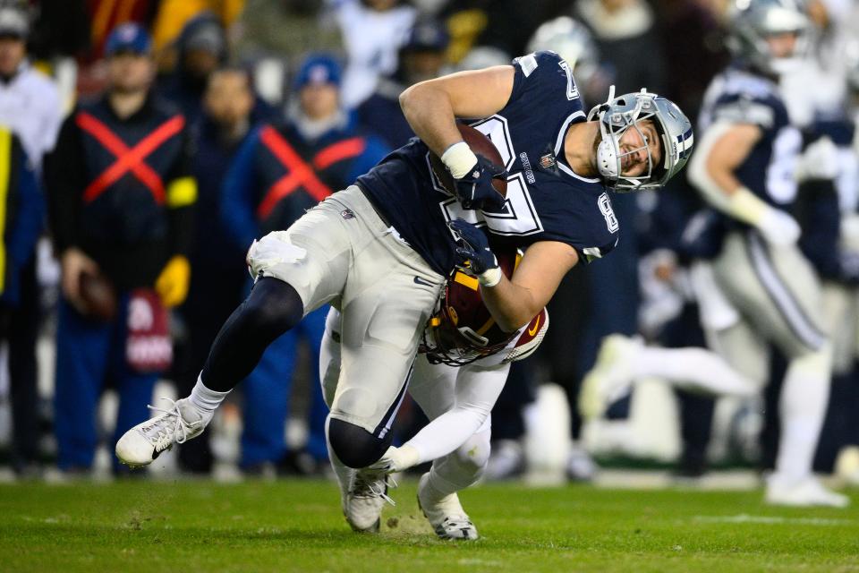 Dallas Cowboys tight end Jake Ferguson (87) is tackled by Washington Commanders safety Darrick Forrest (22) during the first half an NFL football game, Sunday, Jan. 8, 2023, in Landover, Md. (AP Photo/Nick Wass)