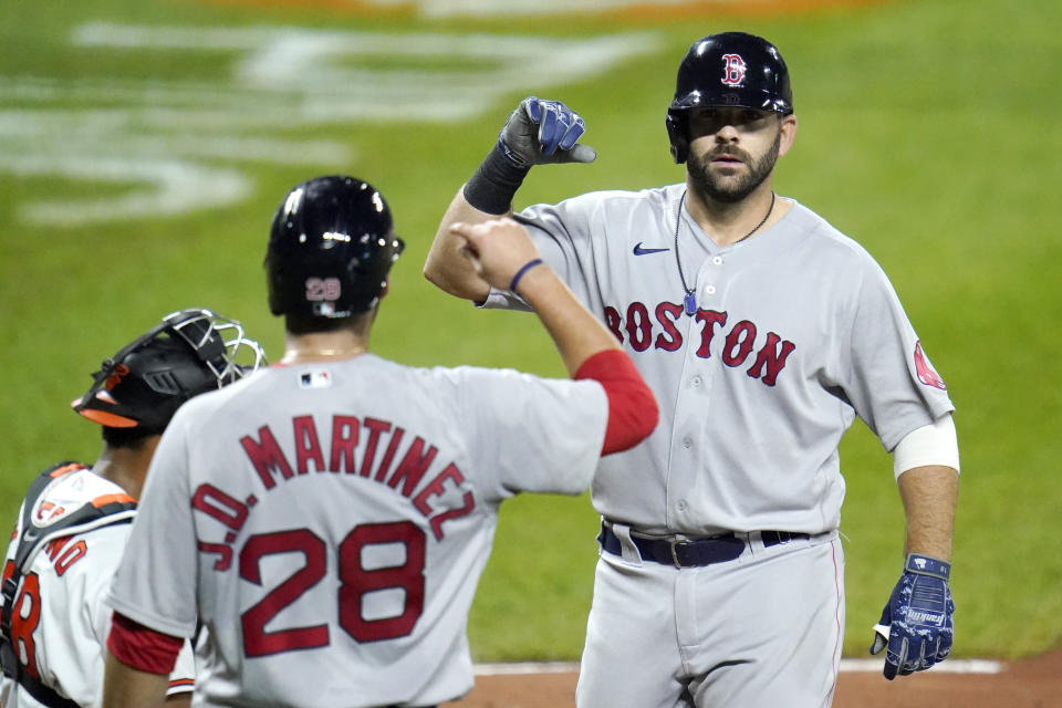 Boston Red Sox's Mitch Moreland, right, is greeted at home plate by J.D. Martinez (28) after hitting a three-run home run off Baltimore Orioles relief pitcher Miguel Castro during the ninth inning of a baseball game, Thursday, Aug. 20, 2020, in Baltimore. The Red Sox won 7-1. Martinez and Xander Bogaerts scored on the home run. (AP Photo/Julio Cortez)