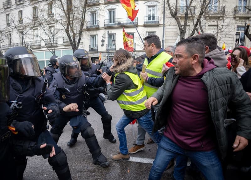 Several demonstrators confront police officers at Puerta de Alcala during the sixteenth day of protests by tractors on Spanish roads to demand improvements in the sector, including aid to address the droughts suffered by the countryside. In addition, they are protesting against European policies and their lack of profitability. Eduardo Parra/EUROPA PRESS/dpa