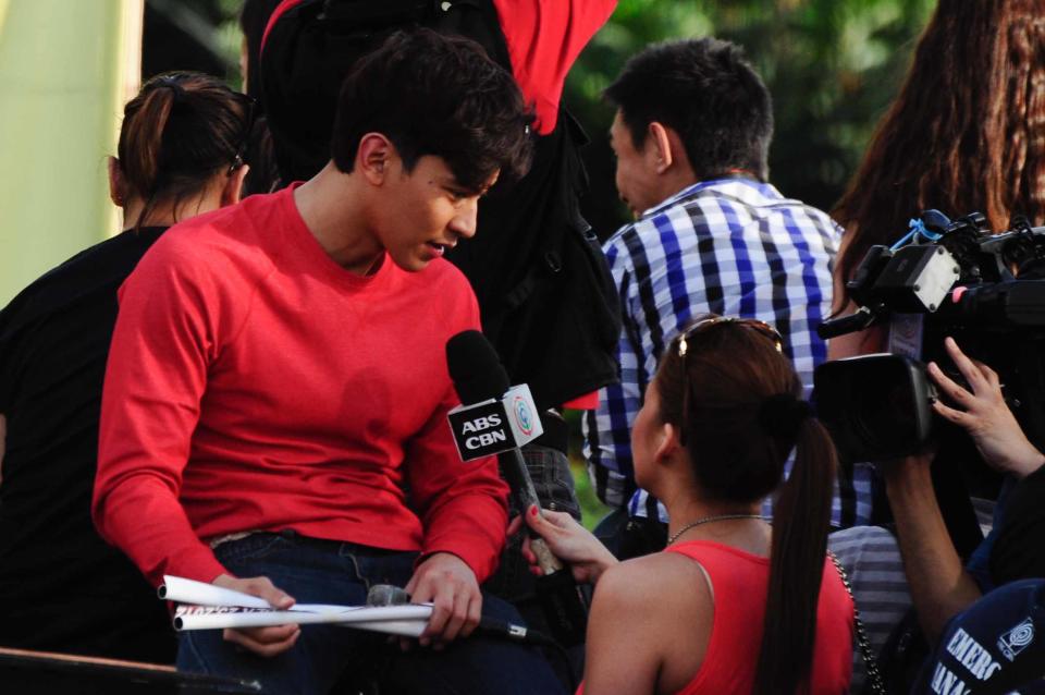 Enchong Dee star of the MMFF 2012 entry "The Strangers" is being interviewed by a journalist during the 2012 Metro Manila Film Festival Parade of Stars on 23 December 2012.(Angela Galia/NPPA Images)