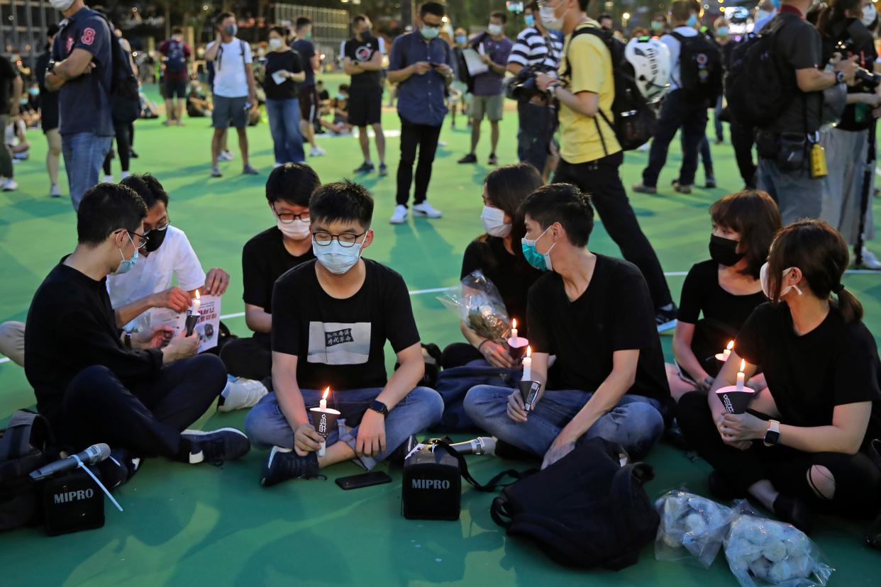 <p>Hong Kong democracy activist Joshua Wong, second left, at the 4 June 2020 vigil for the victims of the 1989 Tiananmen Square Massacre </p> (AP)