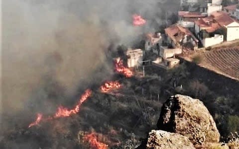 Flames burn close to houses in El Rincon, Tejeda - Credit: Cabildo de Gran Canaria