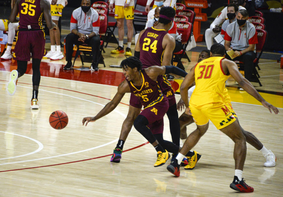 Minnesota's Marcus Carr, front left, splits the defense against Maryland during the first half of an NCAA college basketball game, Sunday, Feb. 14, 2021, in College Park, Md. (Kevin Richardson/The Baltimore Sun via AP)