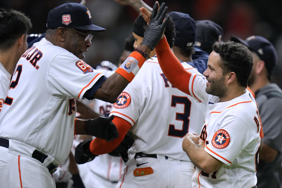 Houston Astros' Jose Altuve celebrates with manager Dusty Baker Jr. after scoring the winning run on a wild pitch by Texas Rangers' Jonathan Hernandez during the 10th inning of a baseball game Wednesday, Sept. 7, 2022, in Houston. (AP Photo/Eric Christian Smith)