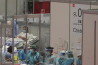 CAPTION CORRECTS THE DATE - In this photo taken on Thursday, April 2, 2020, doctors work at a temporary field hospital set in Ifema convention and exhibition in Madrid, Spain. Most of the 1,850 patients brought to the Ifema field hospital are not in serious conditions. In fact, 800 had been discharged by Thursday, although six had died since doors opened 12 days ago. The new coronavirus causes mild or moderate symptoms for most people, but for some, especially older adults and people with existing health problems, it can cause more severe illness or death. (AP Photo/Manu Fernandez)