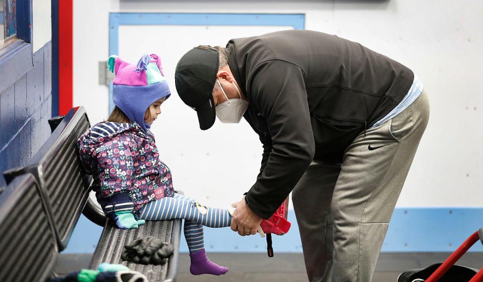 Lulu Magner, 3, gets help from her dad Brian with with her new skating gear.