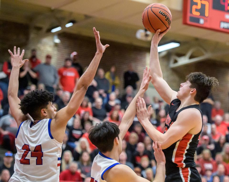 Metamora's Tyson Swanson, right, shoots over Marmion Academy's Travon Roots (24) and Henry Dalmann in the second half of the Class 3A supersectional Monday, March 6, 2023 at Ottawa High School. The Redbirds advanced to the state finals with 60-48 win.