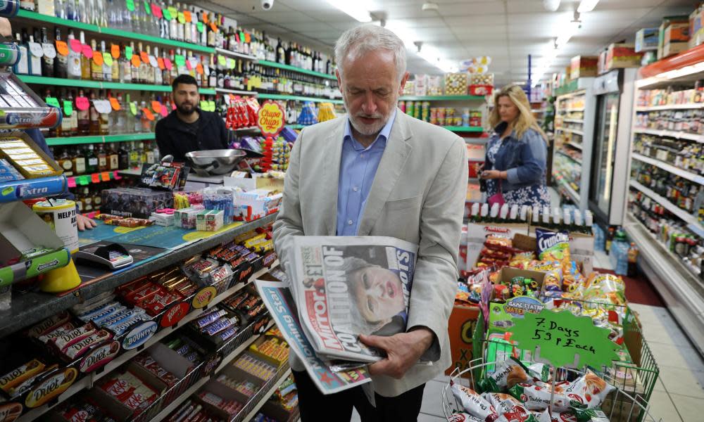 Jeremy Corbyn holding newspapers in a newsagent