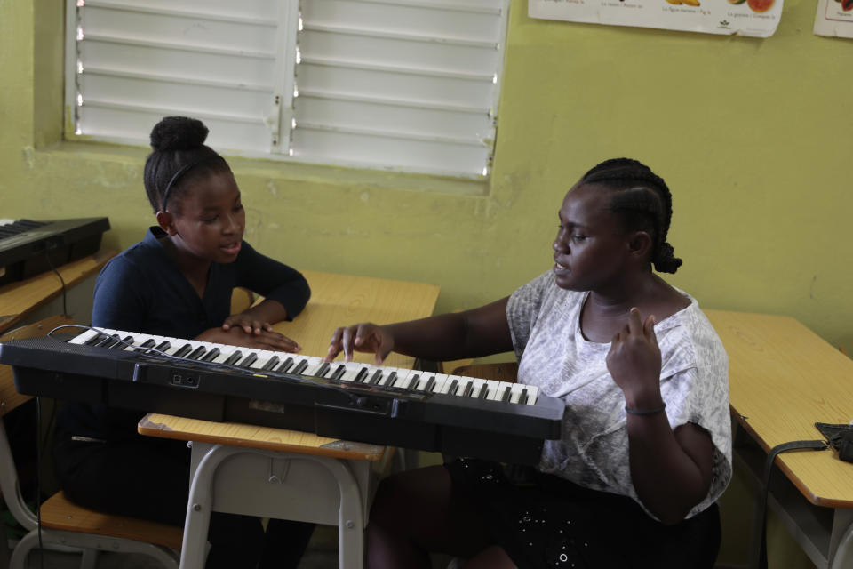 Siltane Alexandre, right, gives a keyboard lesson at the Plezi Mizik Composition Futures School in Port-au-Prince, Haiti, Thursday, Sept. 21, 2023. The after-school music program founded in 2014 by U.S. nonprofit Music Heals International started with 60 children and has grown into a group of 400 enrolled in the $160,000-a-year program offered at eight schools. (AP Photo/Odelyn Joseph)