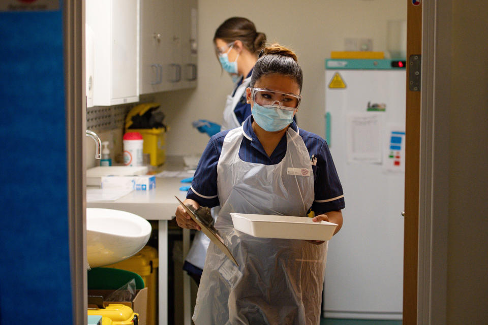 Nurse May Parsons carries a Pfizer/BioNTech covid-19 vaccine at University Hospital Coventry, at the start of the largest ever immunisation programme in the UK's history.