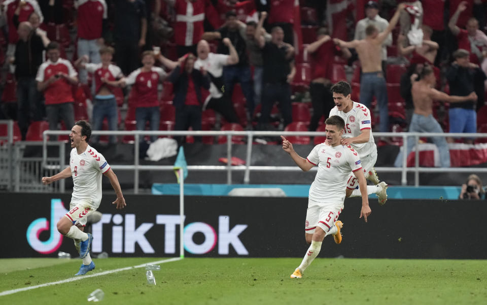 Denmark's Joakim Maehle, centre, celebrates with teammates after scoring his side's fourth goal during the Euro 2020 soccer championship group B match between Denmark and Russia at the Parken stadium in Copenhagen, Monday, June 21, 2021. (AP Photo/Martin Meissner, Pool)