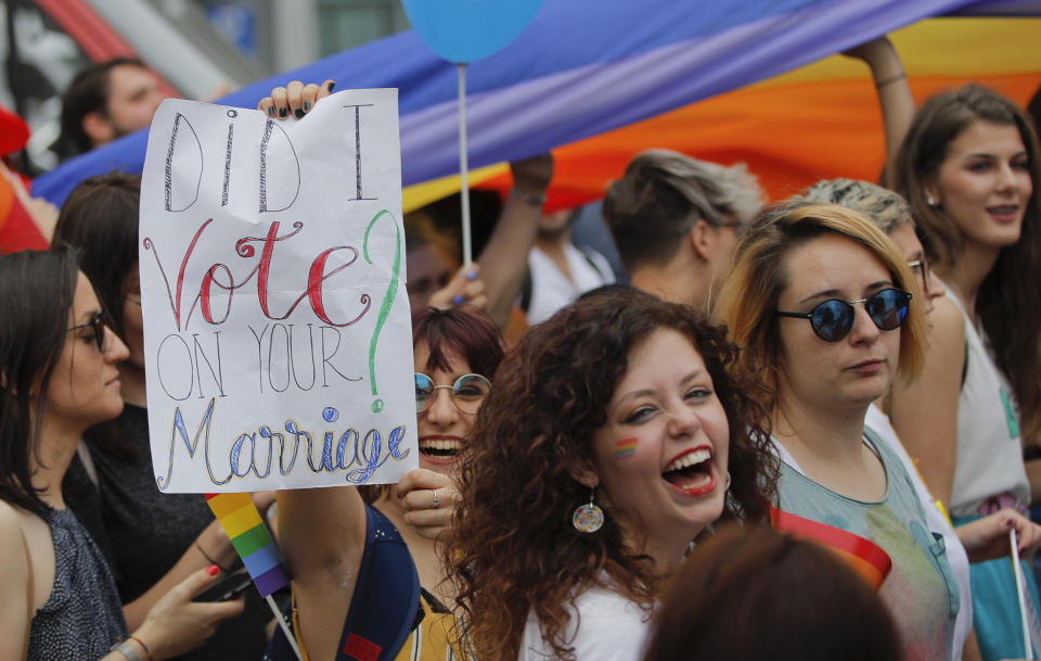 <p>Participants, one holding a banner that reads “Did I vote on your marriage?” react, during a gay pride parade in Bucharest, Romania, Saturday, June 9, 2018. People taking part in the gay pride parade in the Romanian capital demanded more rights and acceptance for same-sex couples. (Photo: Vadim Ghirda/AP) </p>