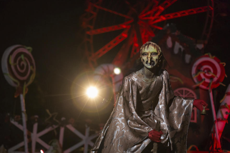 An actor dressed as a witch performs at the Hopi Hari horror theme amusement park, in the Vinhedo suburb of Sao Paulo, Brazil, Friday, Sept. 4, 2020. Due to the restrictions caused by COVID-19, the park created a drive-thru tour that allow the public to enjoy the experience by car. (AP Photo/Carla Carniel)