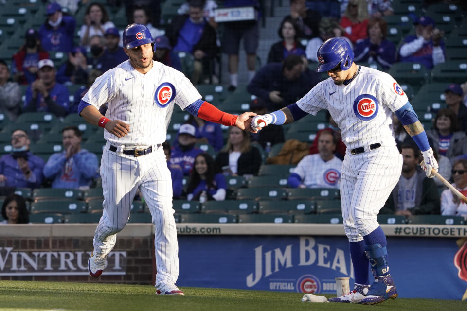 Chicago Cubs' Willson Contreras, left, is greeted by Javier Baez, right, after scoring against the Washington Nationals during the first inning of a baseball game, Monday, May, 17, 2021, in Chicago. (AP Photo/David Banks)