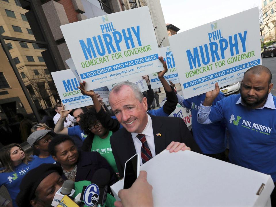 In this April 3, 2017 file photo, Democratic Gov. Murphy rests his hand on a box of petitions in Trenton, New Jersey, as he answers a question before delivering the petitions to meet the deadline for candidates to file petitions to run.