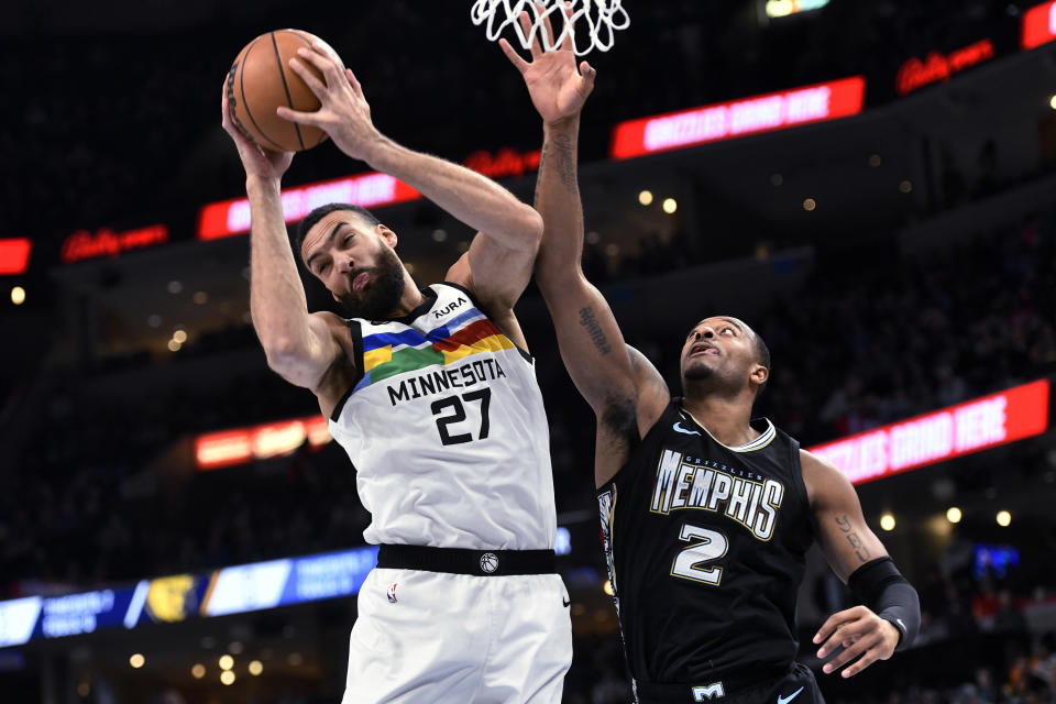 Minnesota Timberwolves center Rudy Gobert (27) grabs a rebound next to Memphis Grizzlies forward Xavier Tillman (2) duirng the first half of an NBA basketball game Friday, Feb. 10, 2023, in Memphis, Tenn. (AP Photo/Brandon Dill)