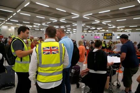 Passengers talk to British government officials at Thomas Cook check-in points at Mallorca Airport after the world's oldest travel firm collapsed, in Palma de Mallorca