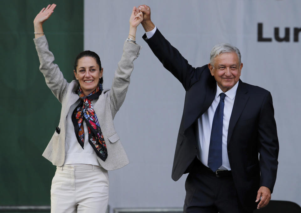 FILE - Mexico's President Andres Manuel Lopez Obrador, right, and Mayor Claudia Sheinbaum, greet supporters at a rally in Mexico City's main square, the Zocalo, July 1, 2019. Immigration is not part of Mexico's political conversation as the country gears up for its presidential vote on June 2. (AP Photo/Fernando Llano, File)