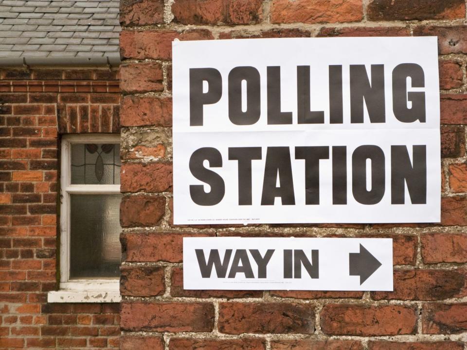 polling station sign on a brick wall