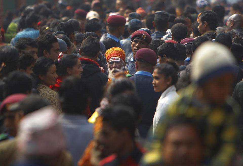 A Hindu holy man walks amid a sea of devotees at the Pashupatinath temple during Shivratri festival in Kathmandu, Nepal, Tuesday, Feb. 17, 2015. 