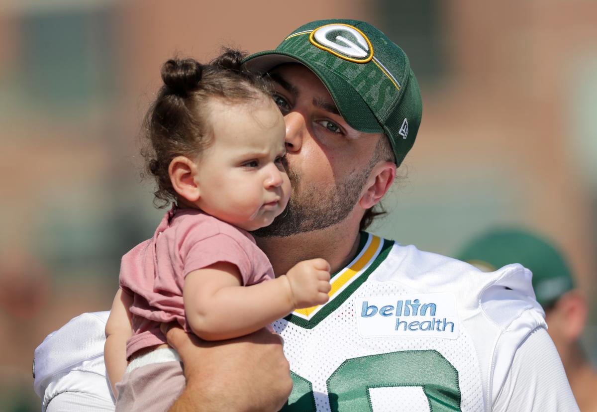 AJ Dillon of the Green Bay Packers rides a bike to training camp