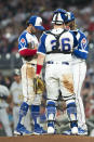 Atlanta Braves shortstop Dansby Swanson, left, and Atlanta Braves catcher Stephen Vogt (26) visit the mound to talk with starting pitcher Touki Toussaint, right, during the top of the third inning of a baseball against the Milwaukee Brewers, Friday, July 30, 2021, in Atlanta. (AP Photo/Hakim Wright Sr.)