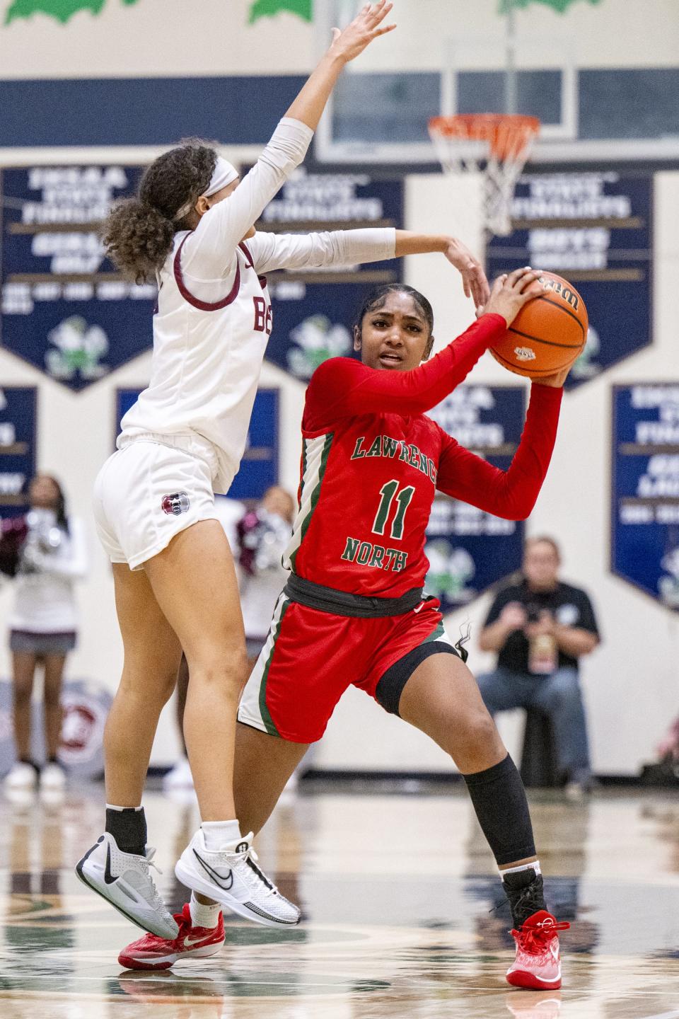 Lawrence North High School senior Kamara Mills (11) is defended by Lawrence Central High School sophomore Aniyah Mckenzie (24) during the second half of an IHSAA Class 4A Sectional semi-final basketball game, Friday, Feb. 2, 2024, at Cathedral High School. Lawrence Central won, 61-54.