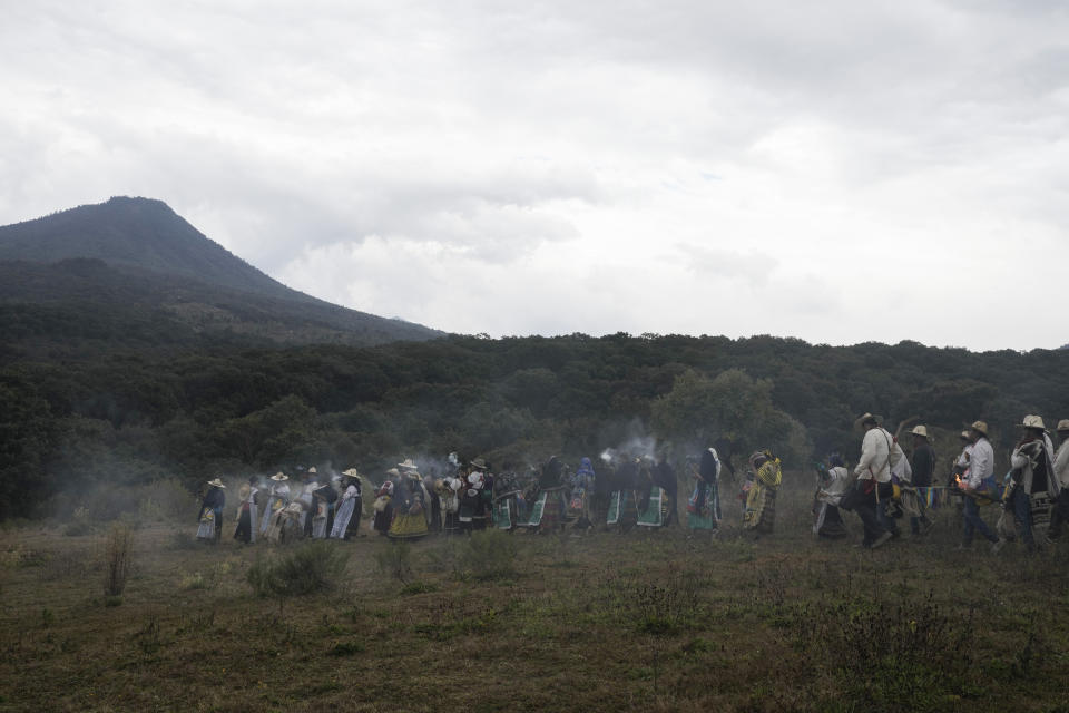 Purepechas Indigenous women carry burning copal incense as they escort a flame from Erongaricuaro, where residents kept the flame alive for one year, to Ocumicho in Michoacan state, Mexico, Wednesday, Jan. 31, 2024. A new fire will be lit in Ocumicho at the “New Fire” ceremony on Feb. 2 to mark the new year, after extinguishing the old fire on Feb. 1 which is considered an orphan day that belongs to no month and is used for mourning and renewal. (AP Photo/Eduardo Verdugo)