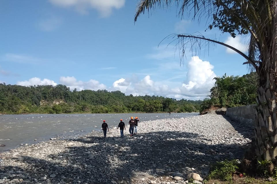 In this photo released by the Disaster Mitigation Agency of Bengkulu Province's Kaur District, rescue team search for victims of a bridge break on a river in Kaur district of Bengkulu province, Indonesia, Monday, Jan, 20, 2020. A footbridge on Indonesia's Sumatra island broke while it was packed with people and several fell into the overflowing river below and drowned, officials said Monday. (Disaster Mitigation Agency of Bengkulu Province's Kaur District via AP)