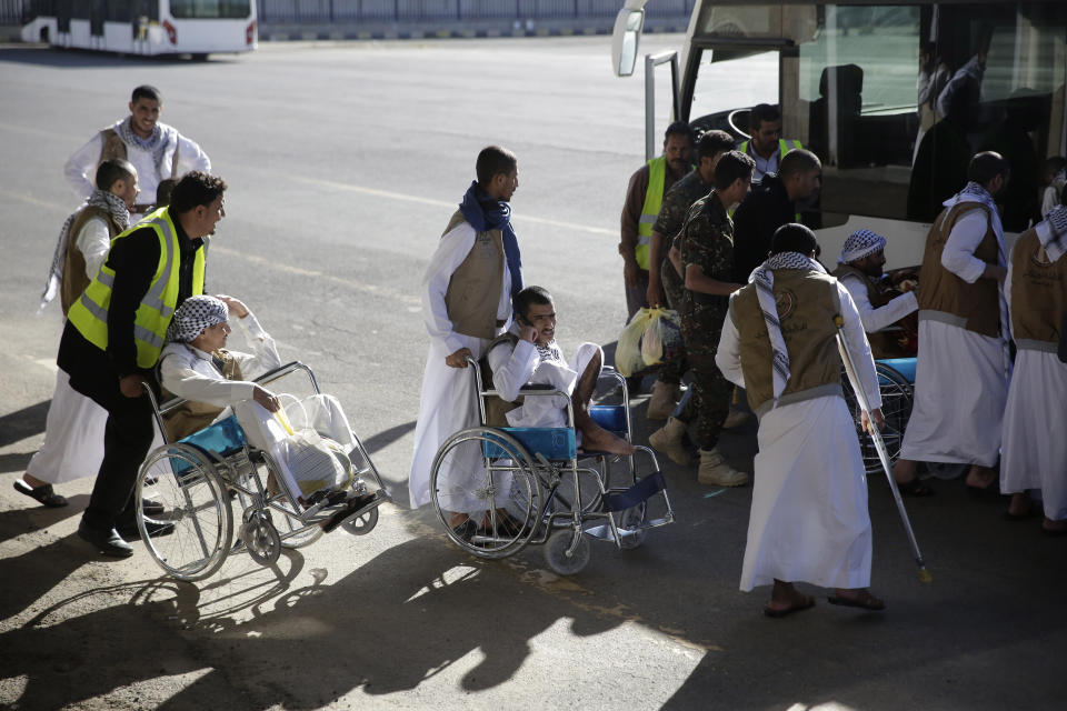 Yemeni prisoners gather during their arrival after being released by the Saudi-led coalition in the airport of Sanaa, Yemen, Thursday, Nov. 28, 2019. The International Committee of the Red Cross says over a hundred rebel prisoners released by the Saudi-led coalition have returned to Houthi-controlled territory in Yemen, a step toward a long-anticipated prisoner swap between the warring parties. (AP Photo/Hani Mohammed)