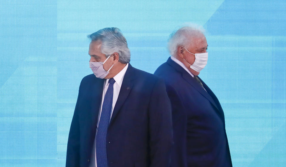 FILE - In this Jan. 14, 2021 file photo, Argentine President Alberto Fernandez, left, walks past Health Minister Gines Gonzalez Garcia as they arrive to a law signing ceremony, in Buenos Aires, Argentina. Fernandez asked his Gonzalez García to resign on Friday, Jan. 19, 2021, who is alleged to be involved in a scandal over discretionary handling of COVID-19 vaccines. (AP Photo/Marcos Brindicci, File)