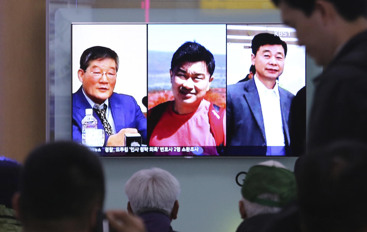 <em>People watch a TV news report on screen, showing portraits of the three American detainees, Kim Dong Chul (left) Tony Kim and Kim Hak Song (right) (AP)</em>