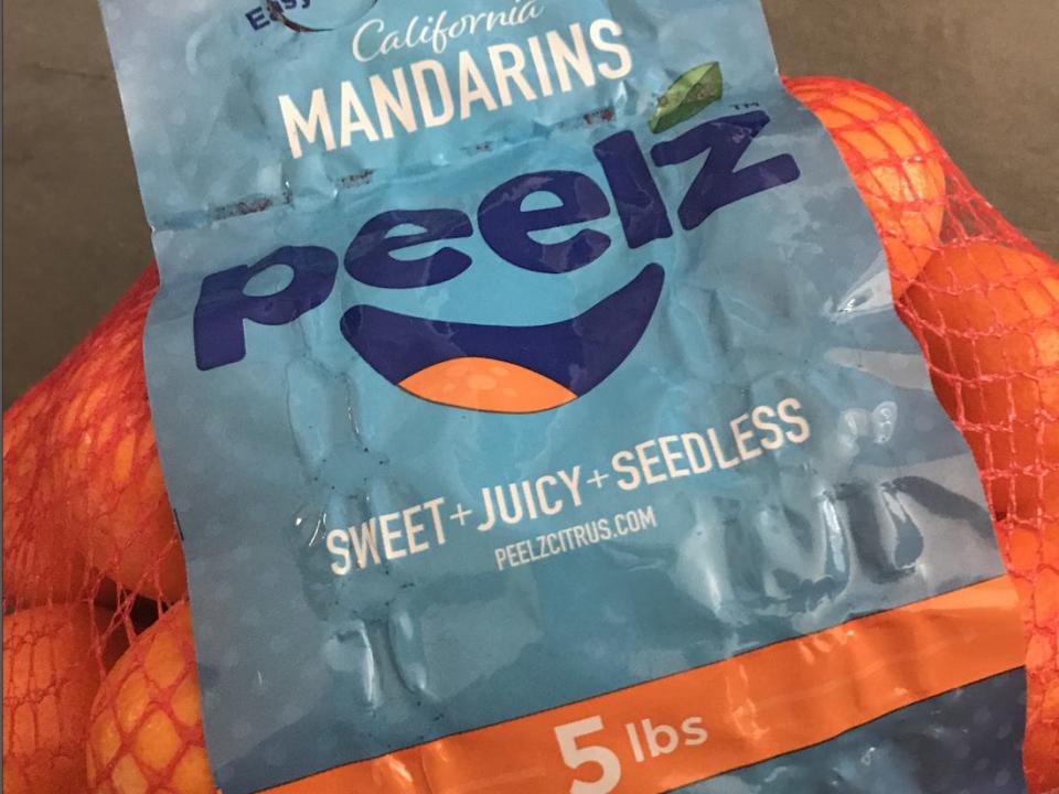 mandarins in a red net bag with a blue label