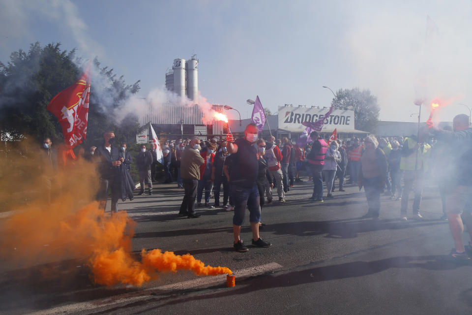 Bridgestone employees fire flares outside the tire factory of Bethune, northern France, Thursday, Sept.17, 2020. Workers protest over the Japan-based company's decision to close the plant and lay off all its nearly 900 workers. Bridgestone argues the factory is no longer competitive globally, but unions and French politicians accused the company of using the virus-driven economic crisis as a pretext for the closure and not investing in modernizing the plant instead. (AP Photo/Michel Spingler)